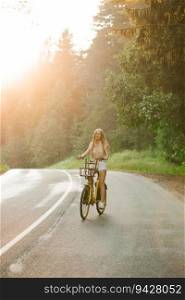 A cheerful young woman enjoys a bike ride on a sunny country outdoor getaway