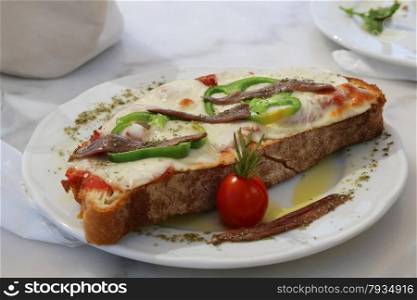A cheese bread or croque monsieur with anchovy