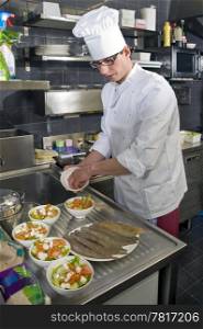 A chef preparing bowls of salad in a professional kitchen