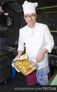 A chef proudly showing a tray of fried potatoes