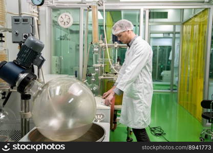 A chemist or apothecary who extracts cannabis, CBD oil, and tinctures using chemical processes. Medical cannabis product manufacturing facility. Cannabis oil extraction machine and equipment.. Scientist apothecary extract using cannabis extraction machine in laboratory.