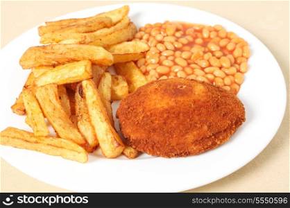 A chicken kiev close-up with baked beans and chips, or French fries.
