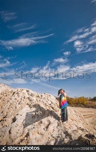 A child launches a rainbow kite.. A child is playing with a kite in the sand 3332.