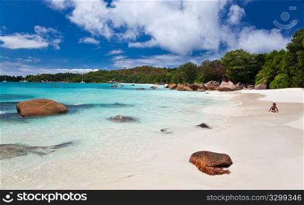 A child plays on the famous beach of Anse Lazio, one of the most beautiful tropical beach in the world. Praslin island, Seychelles, Indian Ocean.