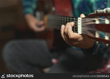 A child plays the classical guitar. detail on the fingers of the left mono that creates a chord