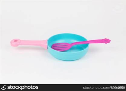 a children&rsquo;s plastic frying pan with a spatula on a white background. children&rsquo;s plastic frying pan with a spatula on a white background