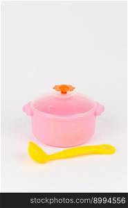 a children&rsquo;s plastic pot with a spatula on a white background. children&rsquo;s plastic pot with a spatula on a white background