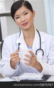 A Chinese Asian female medical doctor drinking tea or coffee in a hospital office&#xA;