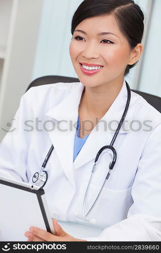 A Chinese Asian female medical doctor using a tablet computer in her hospital office