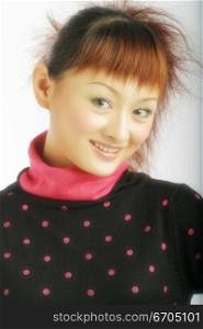 A chinese model poses in fashionable clothing in the studio.