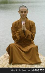 A Chinese monk posing in traditional clothing.