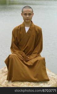 A Chinese monk posing in traditional clothing.