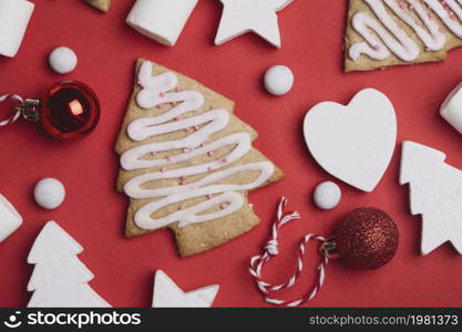 a christmas background. Christmas tree twigs, gingerbread, Christmas balls and cones on a red background