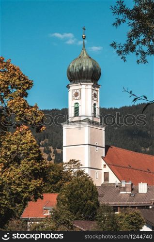 A church in a bavarian village. Blue sky and little white clouds.
