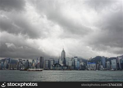 A cityscape of Hong Kong, including the convention center in Wan Chai, over Victoria Harbour from the Kowloon side.