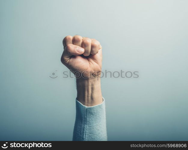 A clenched male fist is up in the air