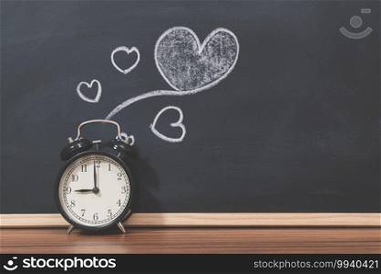 A clock and a heart shape on the blackboard