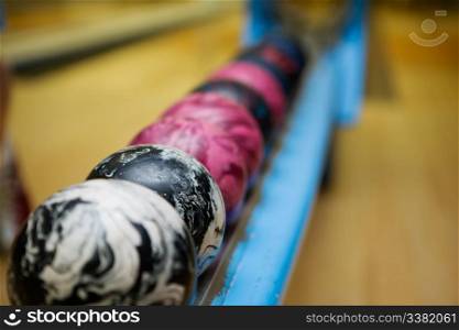 A close up detail image of a set of 5 pin bowling balls. Shallow depth of field is used with focus on the second ball.