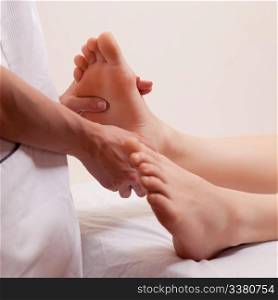 A close-up detail of a masseur giving a foot massage