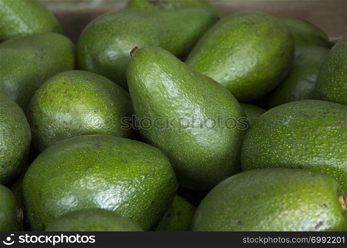 A close up of avocados on display on a market stall