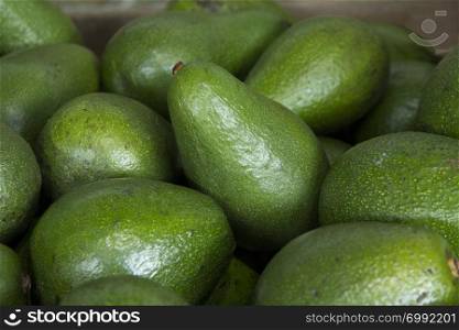 A close up of avocados on display on a market stall