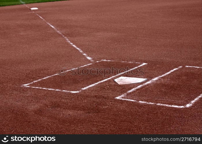 A close-up of the batters boxes and home plate on a vacant baseball diamond.. Clay Batters Boxes