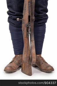a close-up of the soldier's shoes with his rifle
