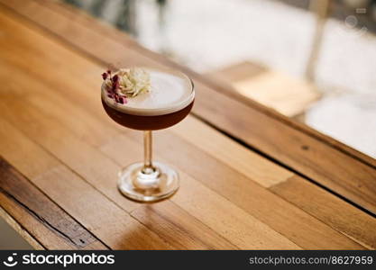 A close up shot of a glass mocktail with rose flower.
. A close up shot of a glass mocktail 