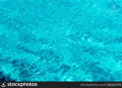 A close up shot of water in swimming pool as the sunlight reflection. Abstract background.