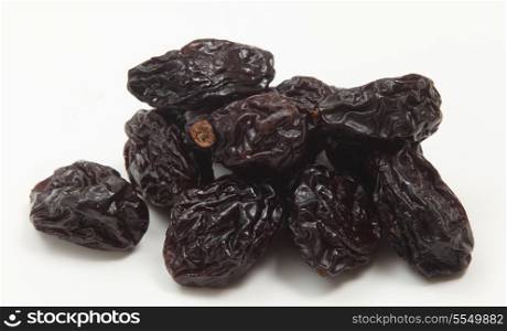 A close-up view of a pile of prunes on a white background