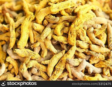A close-up view of turmeric roots on sale in a street market in Kerala, India. They are ground for turmeric powder used in food or Hindu rituals.