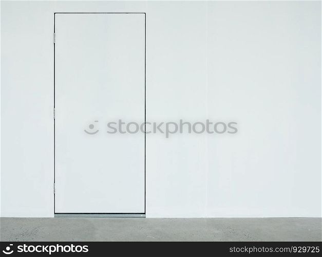 A closed white door on the white wall which located on the back side of the warehouse.