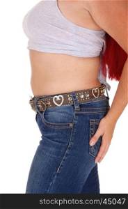 A closeup body part image of the midsection of a woman in jeans andshort top, holding one hand on bottom, isolated for white background.
