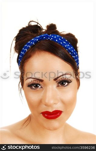 A closeup heat shoot of a gorgeous woman with long eyelashes and redlips and a blue headband in her hair.