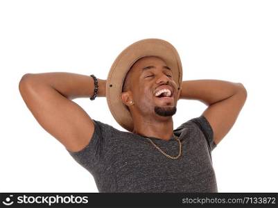A closeup image of a very happy young African American man with his hands behind his head wearing a hat, isolated for white background