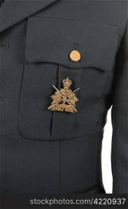 A closeup of a olive green uniform jacket with a medal on the pocket.