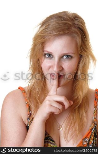 A closeup of a pretty, blond teenager girl with one finger over her mouthtells people be quiet, for white background.