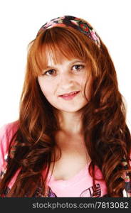 A closeup of a pretty young woman with long red hair for white backgroundwith a headband in her hair, looking into the camera.