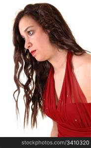 A closeup of a young pretty woman in a red dress in profile standingin the studio for white background.