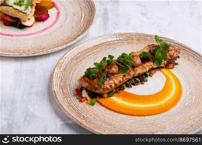 A closeup of beautiful and tasty food on plates isolated on a grey background. Closeup of beautiful and tasty food on plates isolated on a grey background