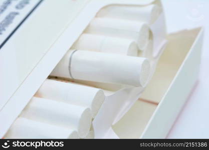 A closeup of open white pack of cigarettes on a white background.