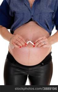 A closeup picture of a Caucasian woman with a big baby belly and blackleather pants break&rsquo;s a cigarette, isolated for white background.