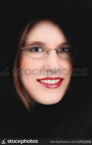 A closeup picture of a very pretty young woman in a black feather hoodwith glasses on.