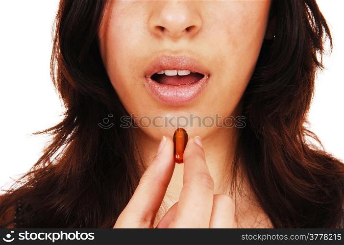 A closeup picture of the face on a young woman with an open mouthtaking a vitamin capsule, isolated on white background.