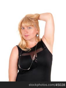 A closeup portrait image of a lovely blond woman standing in a black evening dress, one hand on head, isolated for white background.