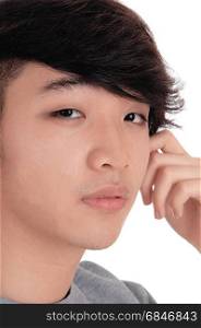 A closeup portrait image of a young Asian man with his hand onhis face, serious, isolated for white background.