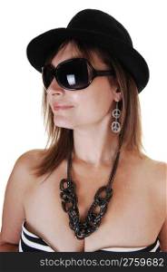 A closeup portrait of a middle aged woman with a black hat and big sunglasses a nice necklace and earrings, in profile.