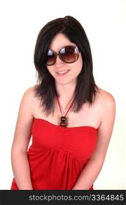 A closeup portrait of a young woman with sunglasses and black hairsmiling into the camera, in a red dress on white background.