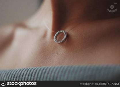 A closeup shot of a female wearing a beautiful silver necklace with a pendant. Closeup shot of a female wearing a beautiful silver necklace with a pendant