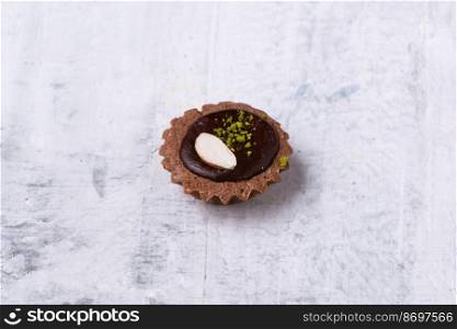 A closeup shot of a Mini Chocolate Hazelnut Tart on a white marble surface. Closeup shot of a Mini Chocolate Hazelnut Tart on a white marble surface